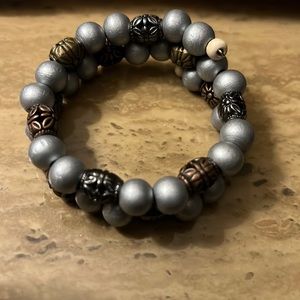 A one of a kind handmade wrap bracelet with gray and metal beads.